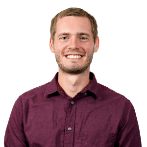 Portrait of a smiling man in burgundy shirt, transparent background.