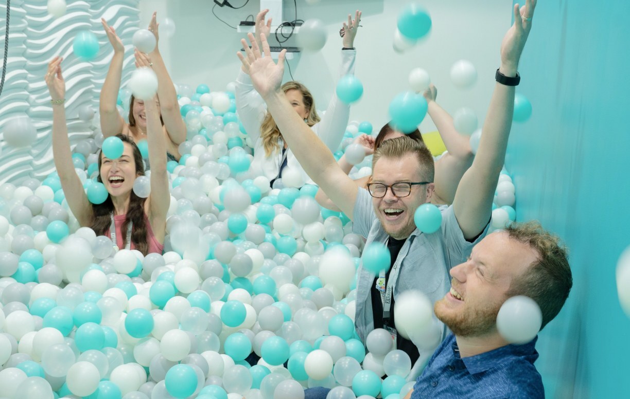 a group of people happily playing a ball pit