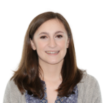 Smiling woman with long hair and a patterned top.