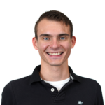 Smiling man in black polo, transparent background, headshot.