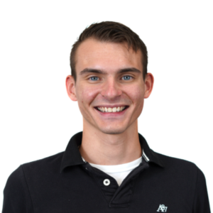 Homem sorridente vestindo uma camisa polo preta, fundo transparente, foto do rosto.