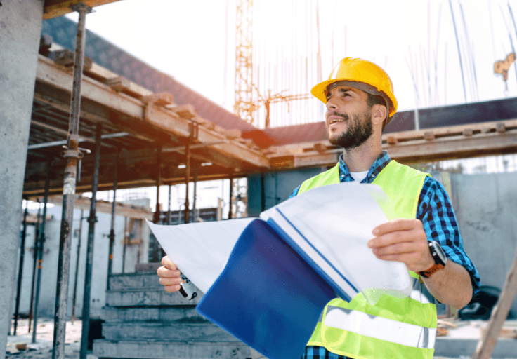 a man wearing a hard hat and is holding a blue folder