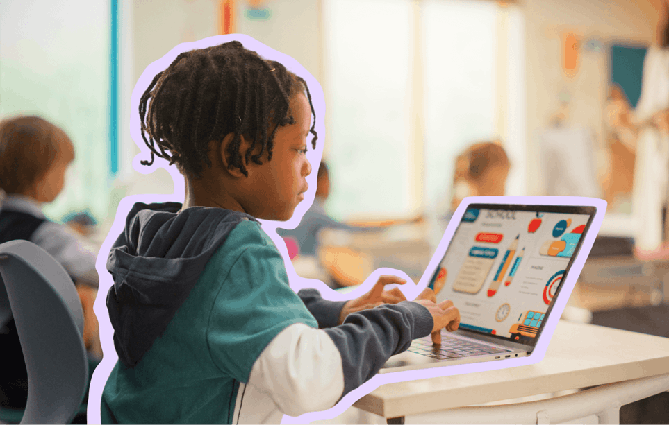 Young child doing work on a laptop in a classroom