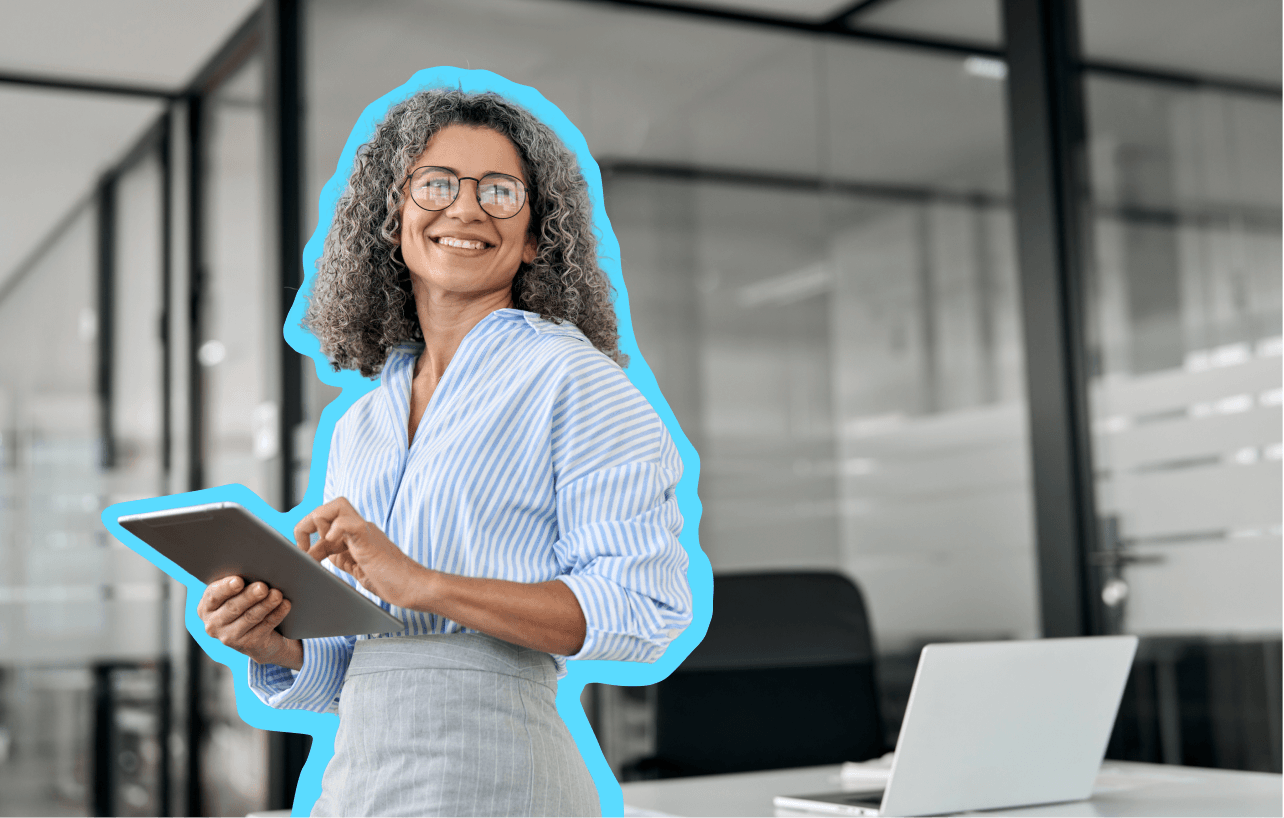 Woman in professional clothing standing in an office with a tablet in her hand
