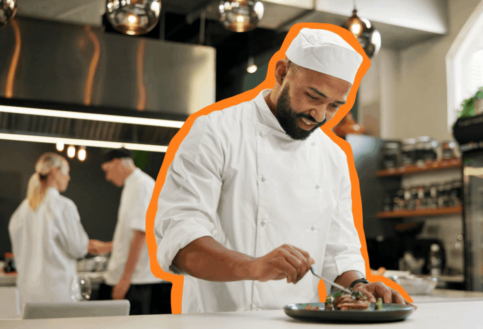 Chef putting finishing touches on a plate of food