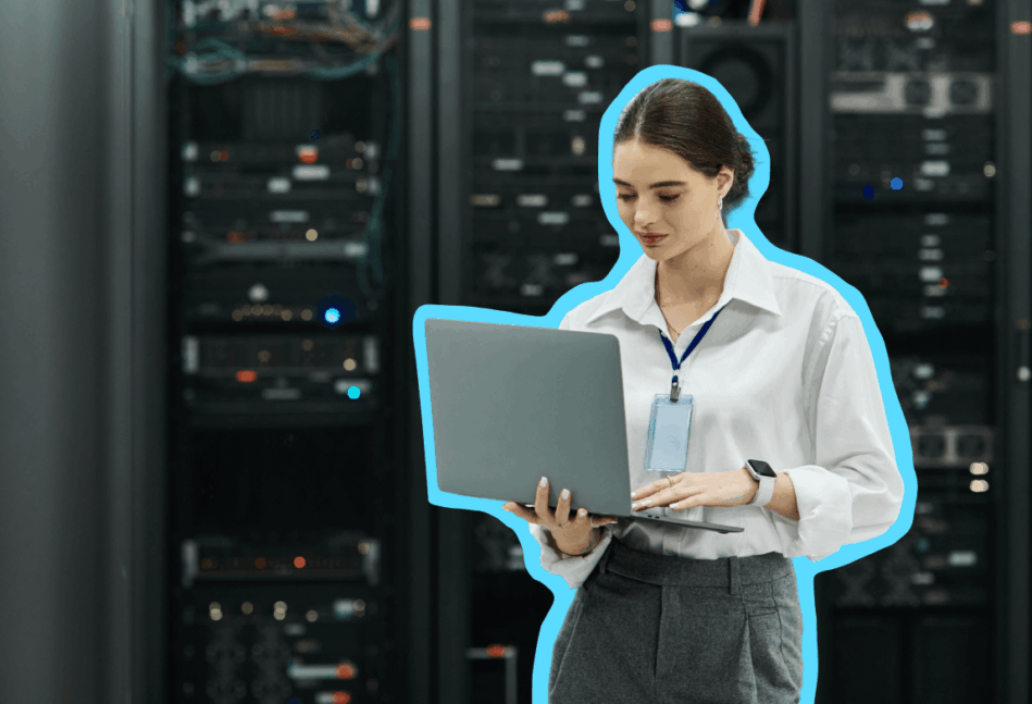 Woman on a computer standing in a room of servers