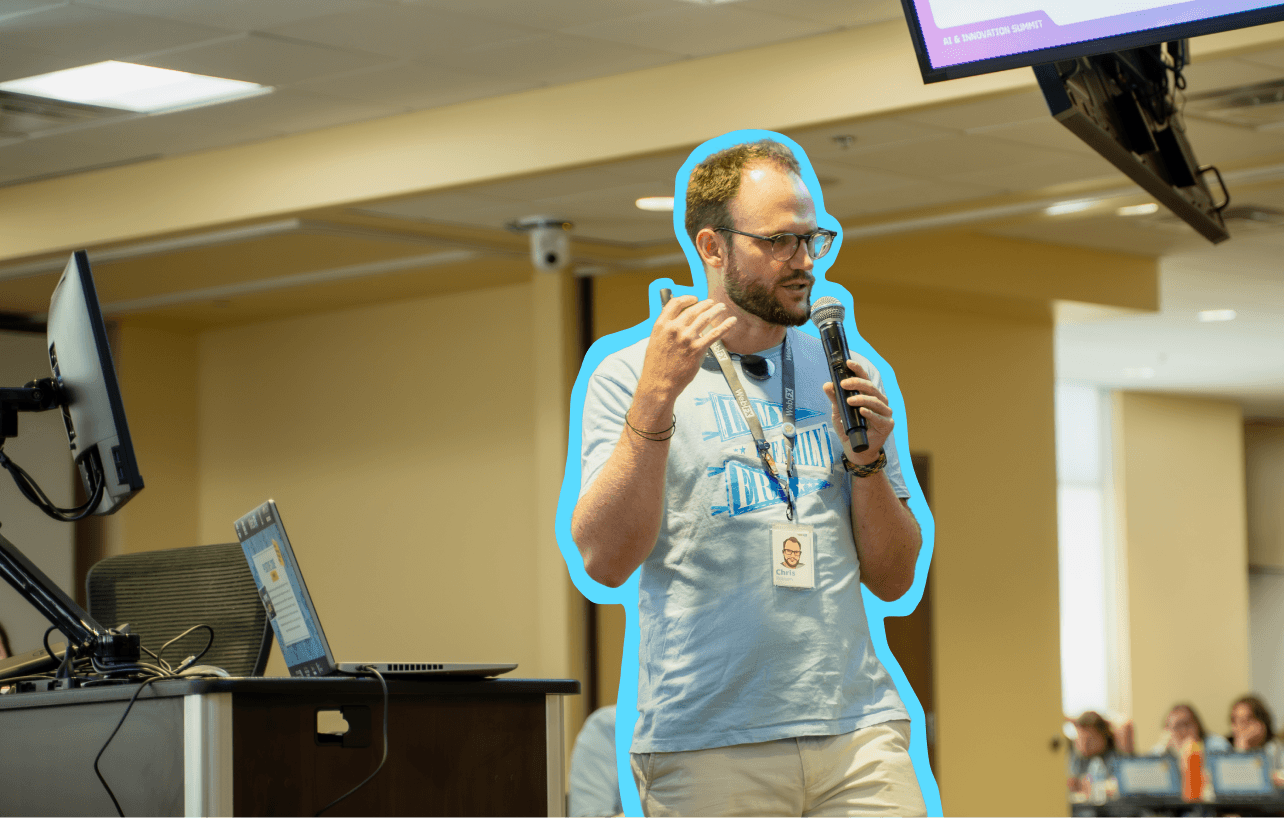 Man in a blue shirt speaking into a microphone